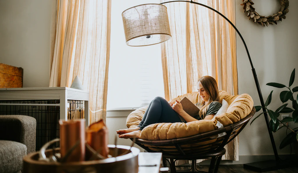 A woman reading quietly in a softly lit room